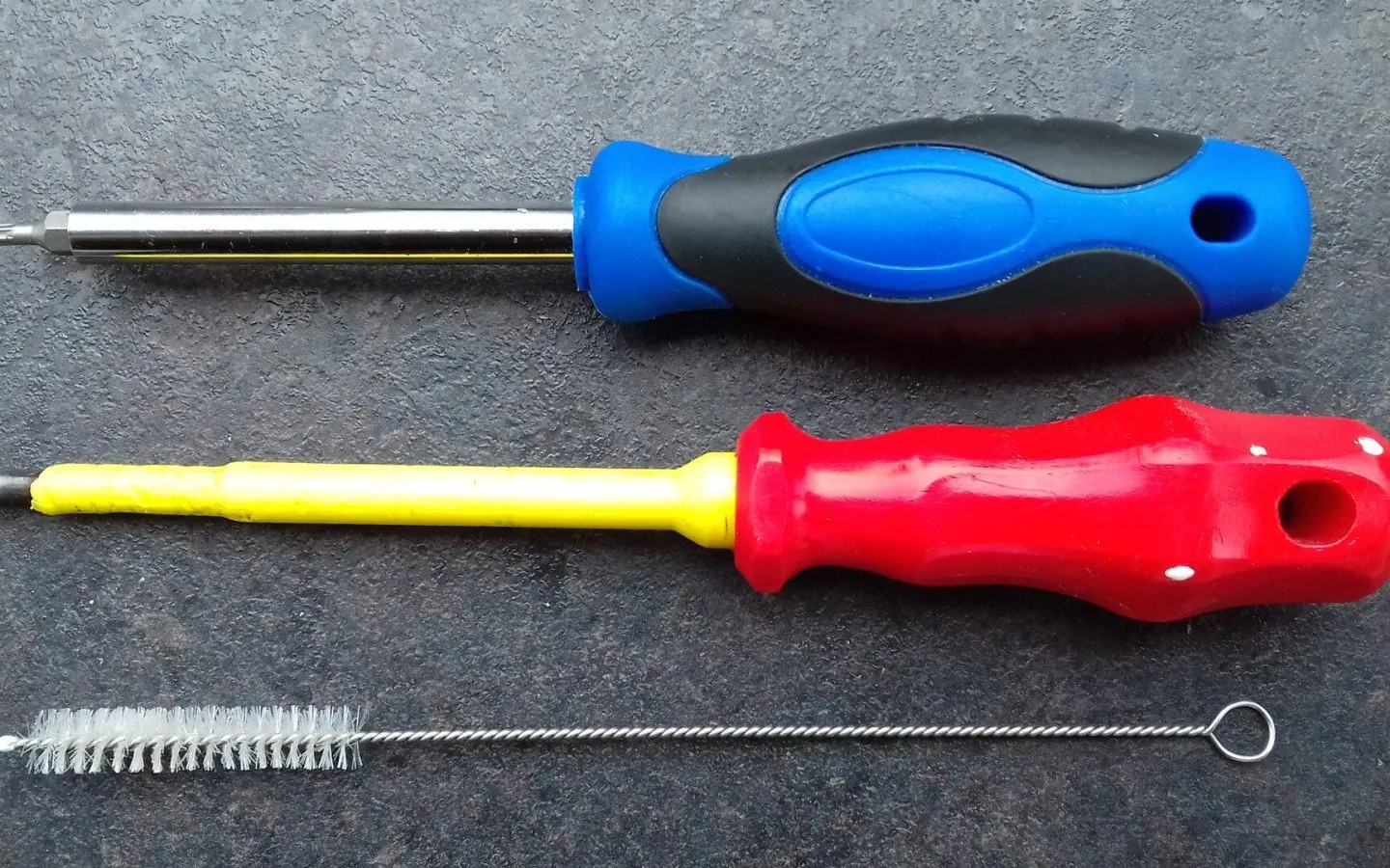 Hands repairing a device with tools on a workbench