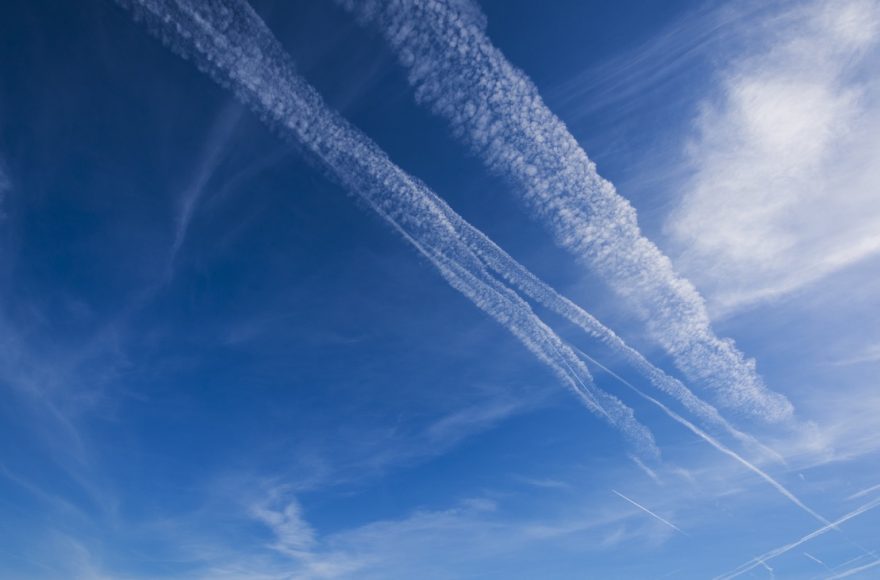 Aircraft contrail against a blue sky, illustrating Google’s AI contrail avoidance trial