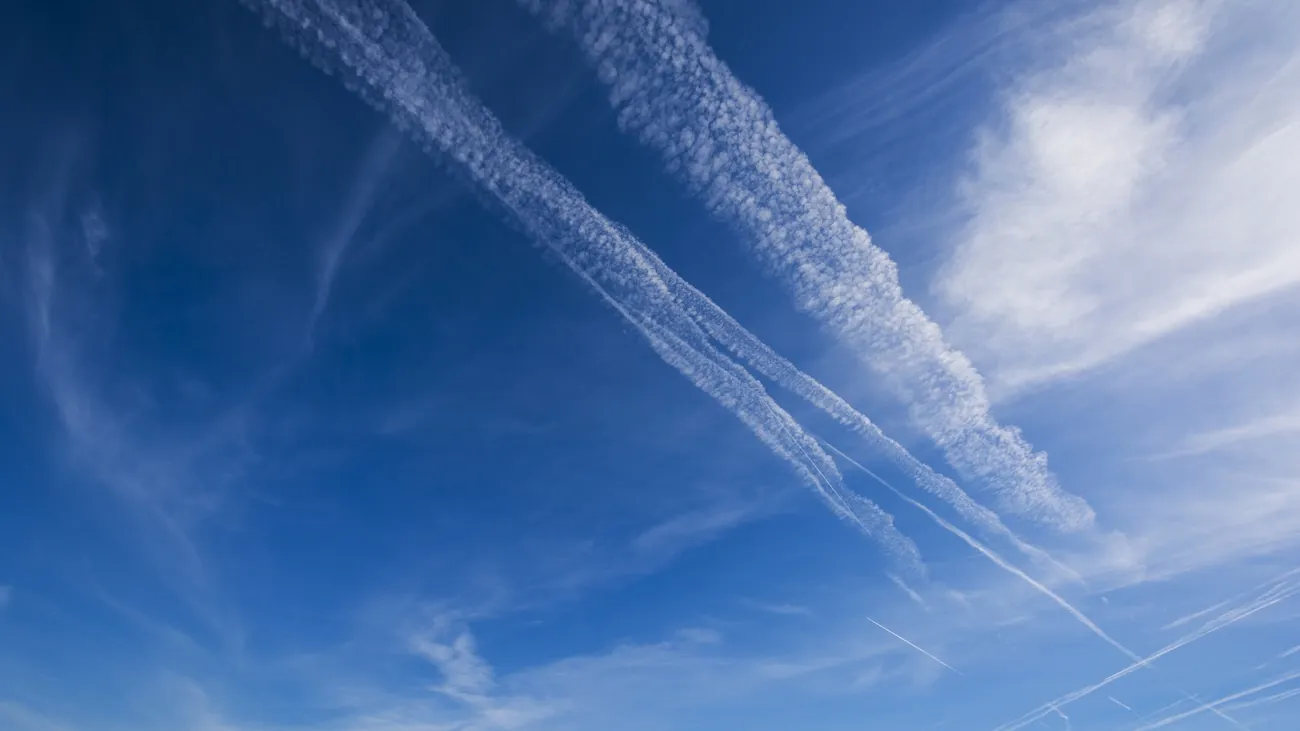 Aircraft contrail against a blue sky, illustrating Google’s AI contrail avoidance trial