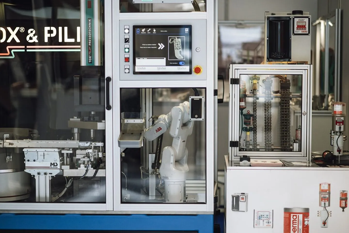 Industrial robot arm working inside a machinery cell in a factory.