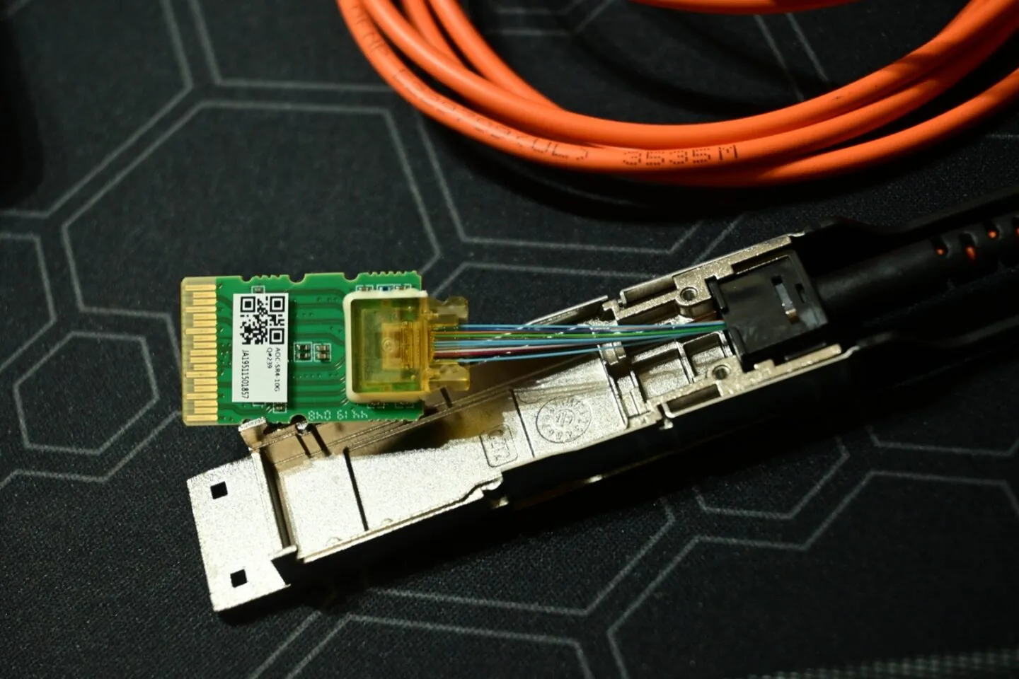 Disassembled 40 Gb/s QSFP optical transceiver with exposed circuit board, fiber strands, and metal housing; illustrative only, not a USFP prototype.