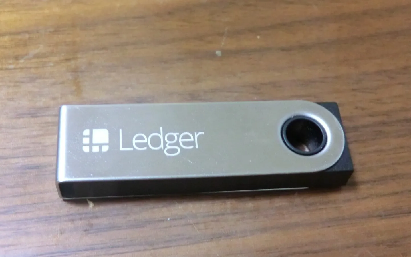 Illustrative Ledger Nano S hardware wallet on a wood surface, not evidence of the device in Ledger's investigation.
